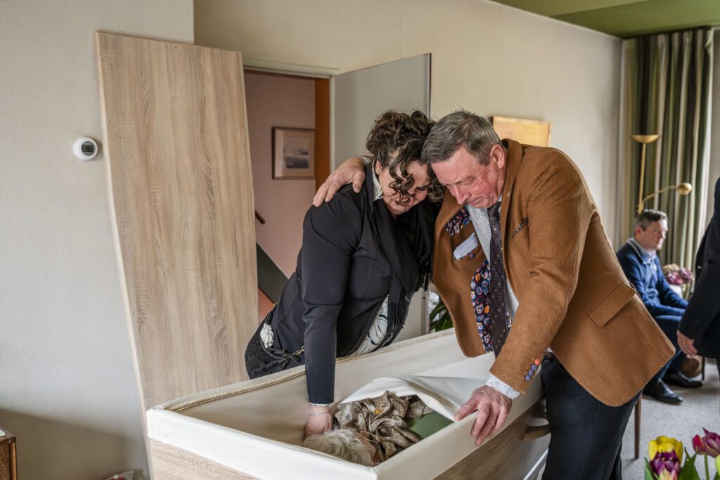 broer en zus zoeken steun bij elkaar. unieke foto uitvaartfotografie